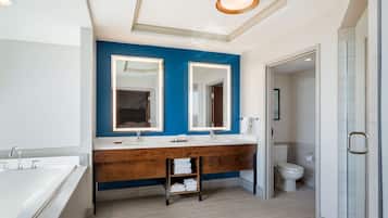 Un baño moderno con un espejo grande, lavamanos dobles y cabina de ducha a ras de suelo.