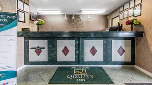 A reception area with a marble counter, framed certificates, and a welcome mat. - Quality Inn Andalusia (Andalusia)