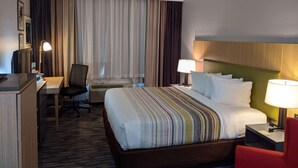 A hotel room with a bed, desk, chair, and a television. - Country Inn & Suites by Radisson, Nashville, TN (Nashville)