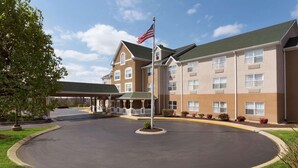 A hotel with a central courtyard, a flagpole with an American flag, and a covered walkway. - Country Inn & Suites by Radisson, Nashville, TN (Nashville)