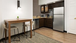A compact kitchen with a wooden table, two chairs, a microwave, a coffee maker, and a refrigerator. - Residence Inn by Marriott West Palm Beach (West Palm Beach)