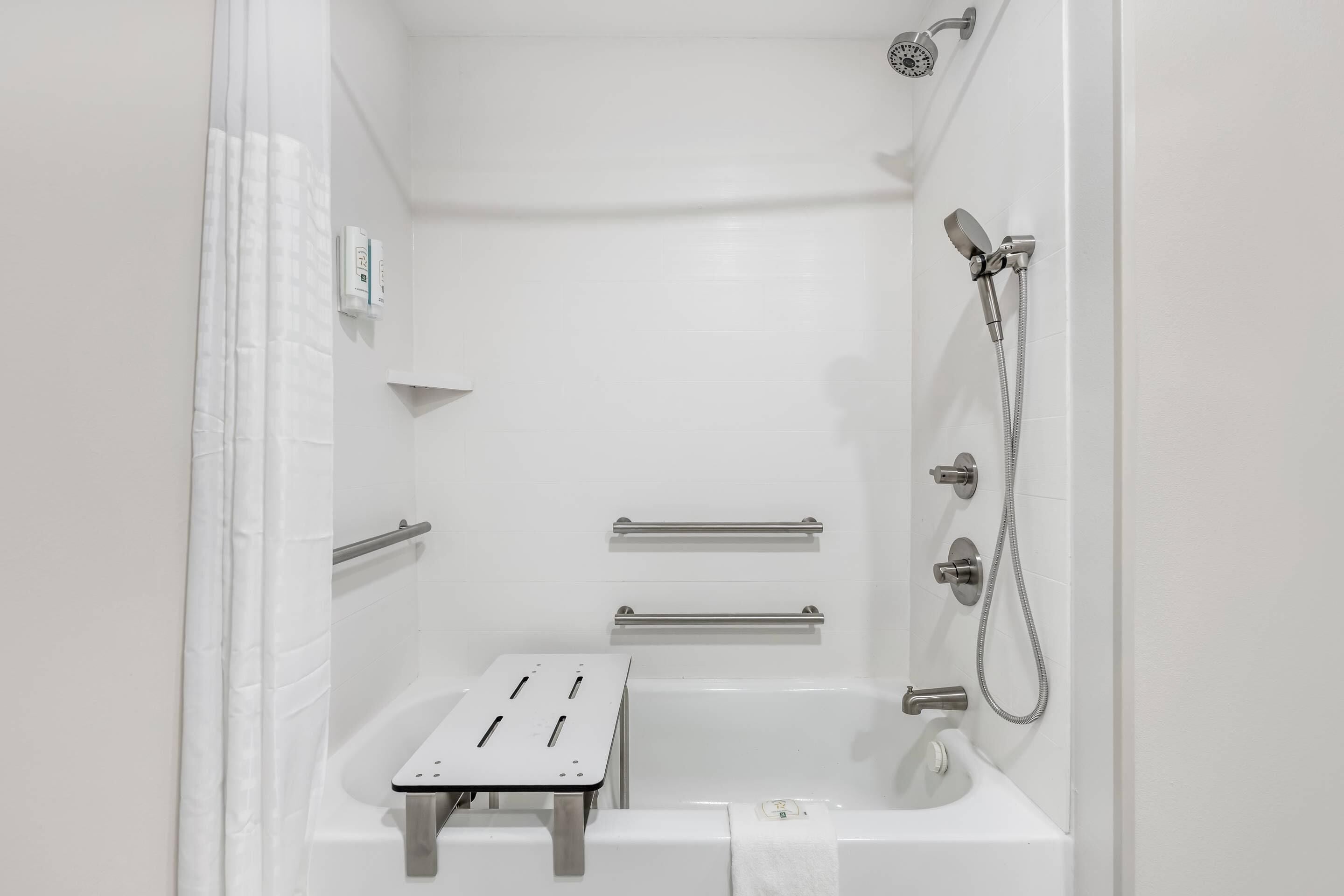 Ein modernes Badezimmer mit Badewanne, Dusche und Handtuchhalter.