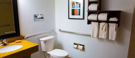 A bathroom with a sink, toilet, towel rack, and a framed picture on the wall.