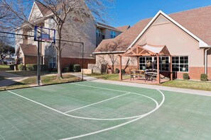 An outdoor basketball court adjacent to a building with a covered patio area. - Residence Inn Waco (Waco)