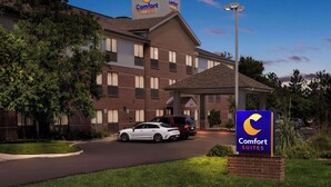 A Comfort Suites hotel with a brick facade, a covered entrance, and a signboard.