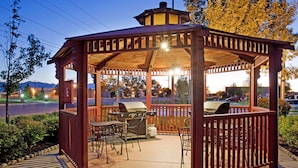 A gazebo with a grill and seating area, surrounded by trees and a view of a road. - Sonesta Simply Suites Salt Lake City Airport (Salt Lake City)