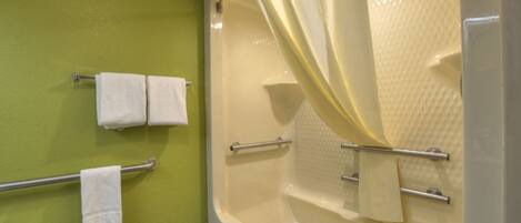 A bathroom with a bathtub, a shower curtain, and two towels on a towel rack.