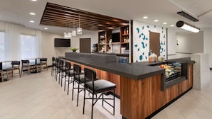 Eine moderne Bar mit Holztresen, Barhocker und einem Fernseher.