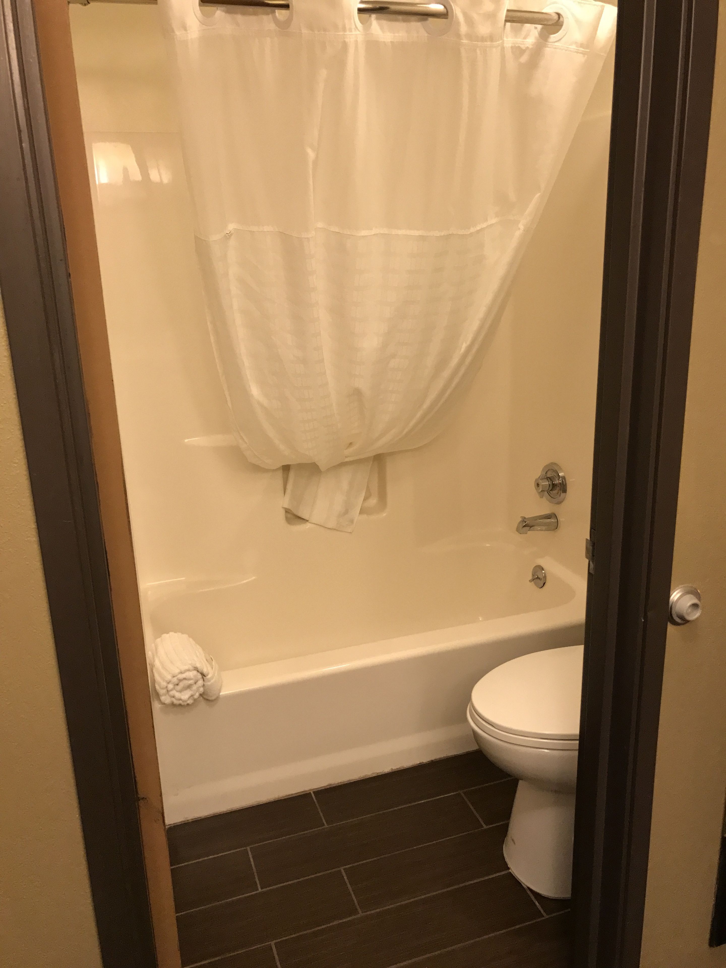 Une salle de bain avec une baignoire, des toilettes et un rideau de douche.