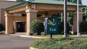A hotel entrance with a green roof, a sign indicating an exit, and a number '5441' on the building. - Quality Inn Magee (Magee)