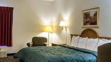 Tabla de planchar con plancha, ropa de cama y despertador