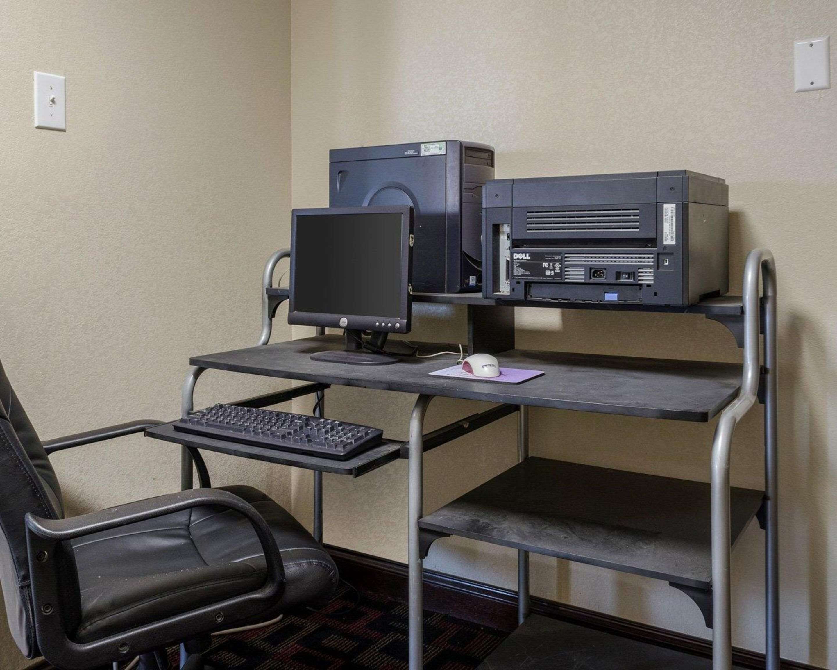 A compact office setup with a desk, chair, computer, and keyboard.