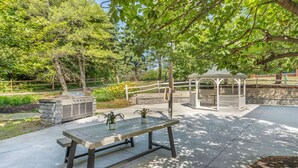 An outdoor patio with a wooden table, a gazebo, and potted plants. - Executive Residency by Best Western Philadelphia-Willow Grove (Horsham)
