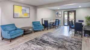 A modern hotel lobby with blue armchairs, a round table, and a dining area with chairs. - Executive Residency by Best Western Philadelphia-Willow Grove (Horsham)