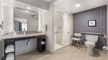 Un baño moderno con ducha, inodoro y tocador.