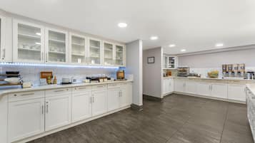A modern kitchen with white cabinetry, a breakfast bar, and a breakfast bar sign.