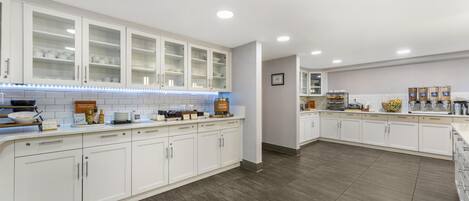 Una cocina moderna con armarios blancos y una barra desayunadora, además de un letrero que dice 'barra de desayuno'.