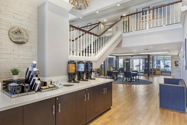 A hotel lobby with a coffee station, wooden flooring, and a staircase. - Homewood Suites by Hilton Philadelphia Great Valley (Malvern)