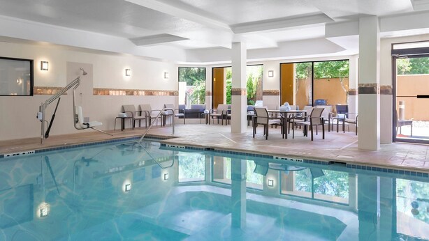 Ein Schwimmbecken mit Sonnenterrasse und einer Sitzgelegenheit im Freien.