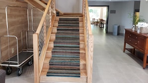 A wooden staircase with a patterned carpet, leading to a room with a dining area and a wooden cabinet. - Country Inn & Suites by Radisson, Rock Hill, SC (Rock Hill)