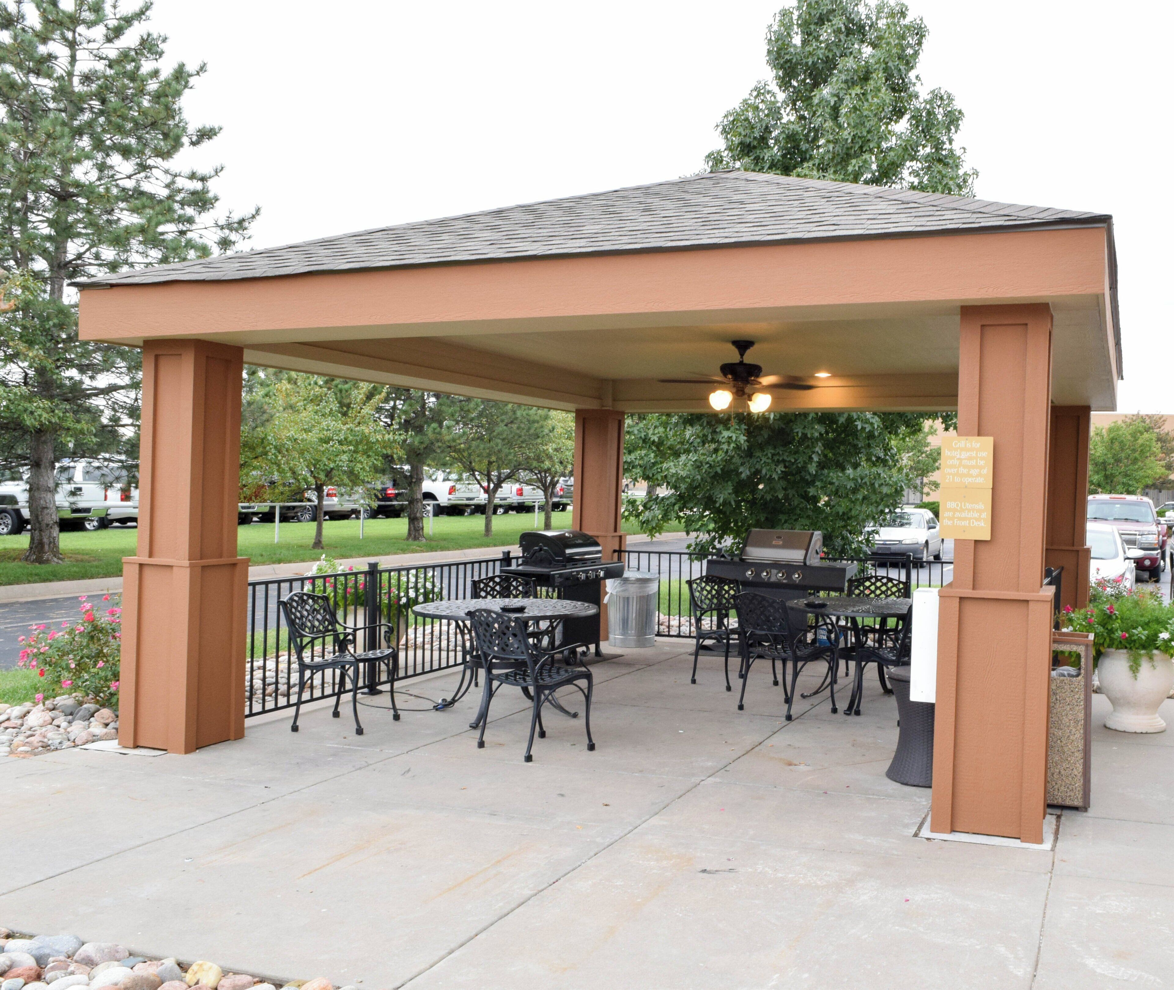 Un patio couvert avec des meubles d’extérieur et un barbecue.