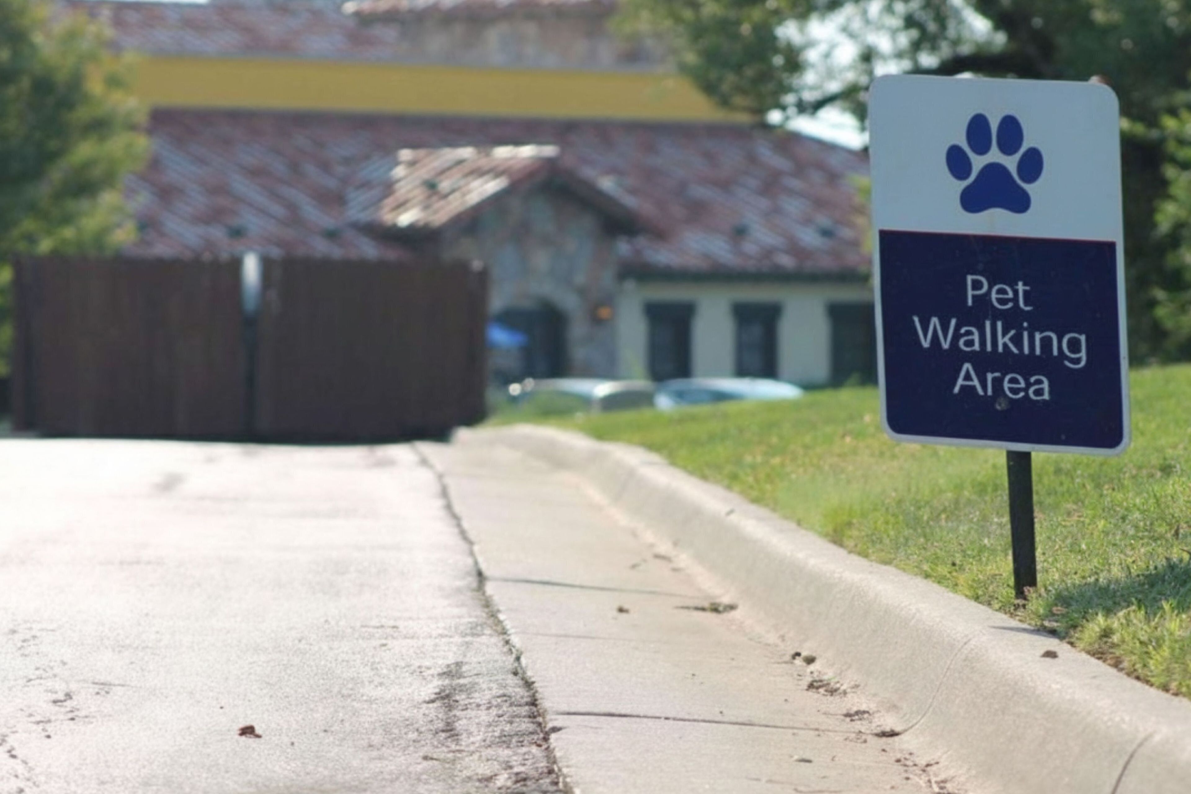 A sign indicating a pet walking area.