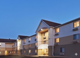 A multi-story hotel with a modern architectural design, featuring a central atrium and multiple balconies.