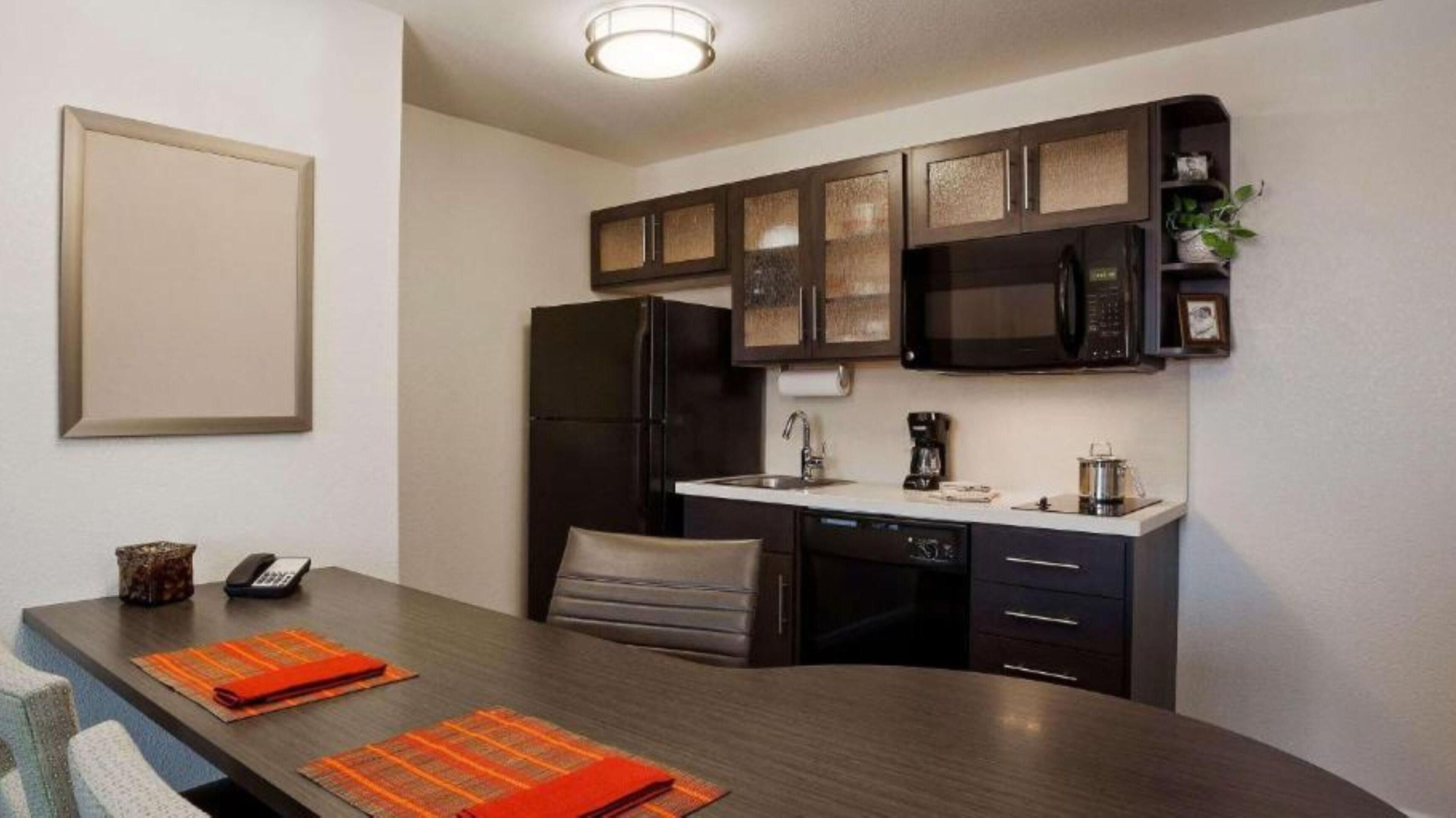 A compact kitchen with a refrigerator, microwave, and coffee maker.