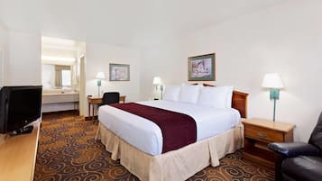 Een hotelkamer met een bed, een bureau, een televisietoestel en een stoel.