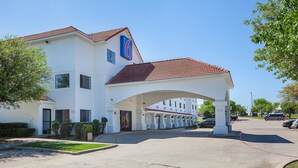 A white building with a red-tiled roof and a large '6' sign. - Motel 6 Bedford, TX - Fort Worth (Bedford)