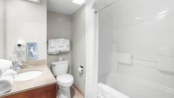 Un baño con lavamanos, inodoro y zona de ducha.