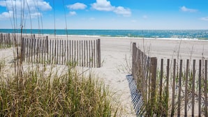 A beach with wooden fences and sand.