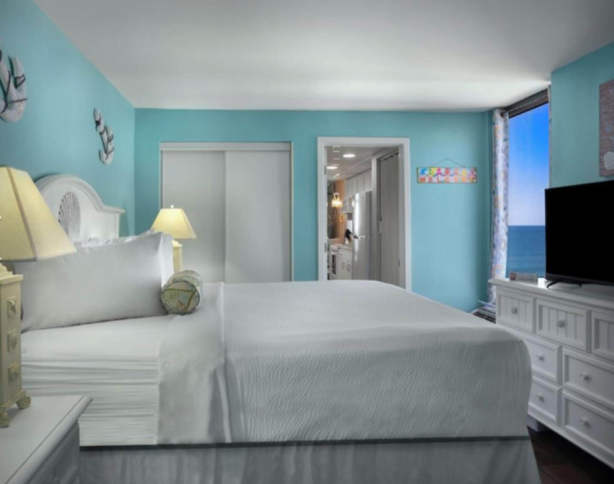 Un dormitorio con cama, mesita de noche, lámpara y televisión.
