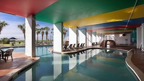 Un área de piscina con sillas de descanso y una escalera que lleva a un nivel superior.