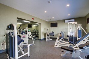 A gym with various exercise equipment, a television mounted on the wall, and a ceiling-mounted fire alarm. - Holiday Inn Express Fort Campbell-Oak Grove by IHG (Oak Grove)