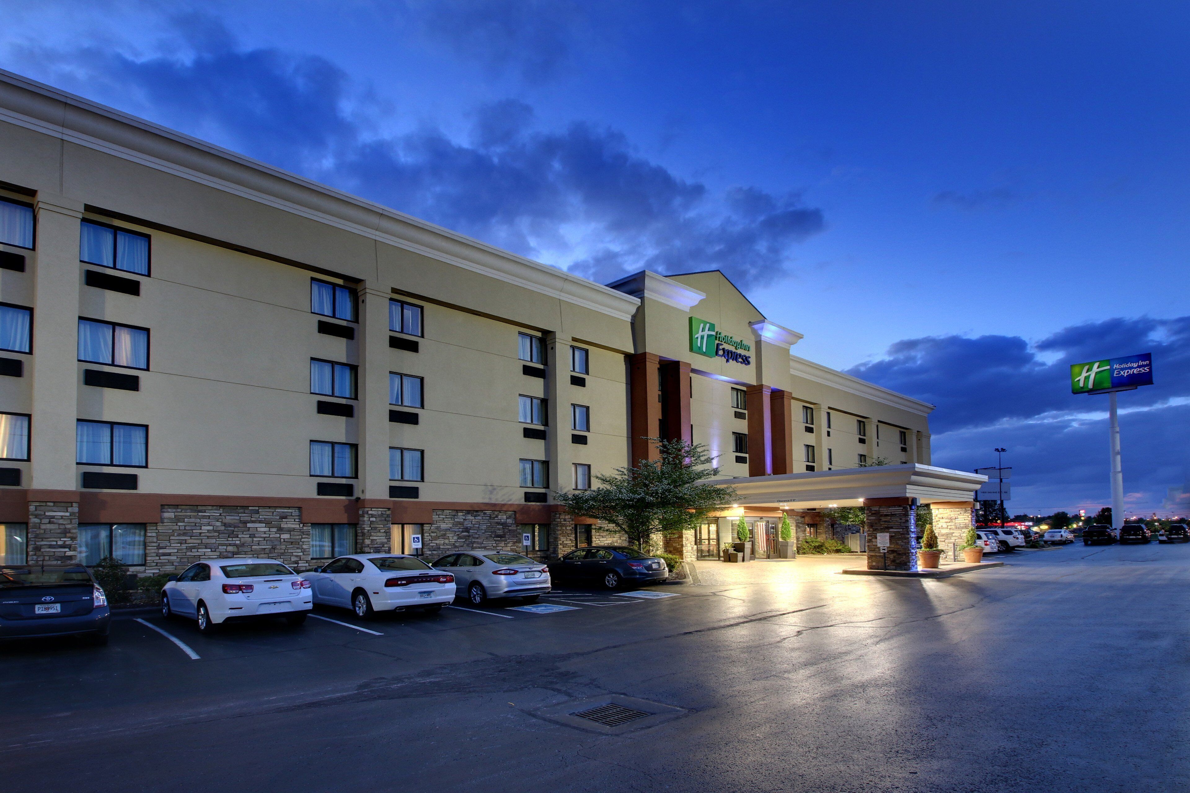 A Holiday Inn Express hotel with a parking lot and several cars parked in front.