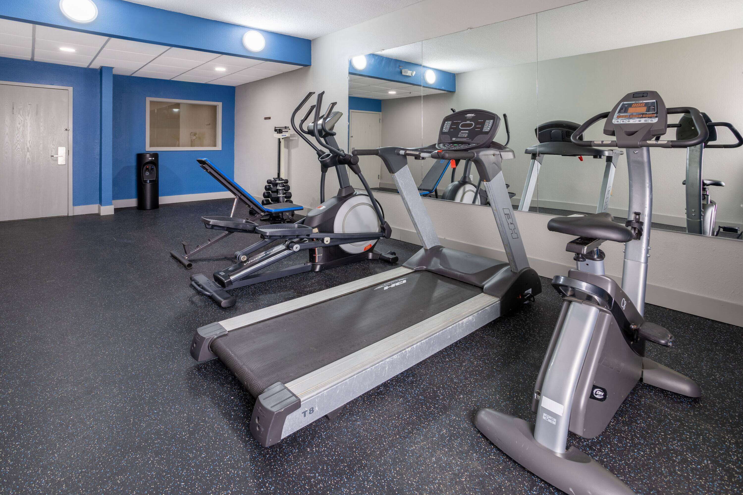 Une salle de sport équipée de tapis de course, d’un vélo elliptique et d’un vélo d’appartement.