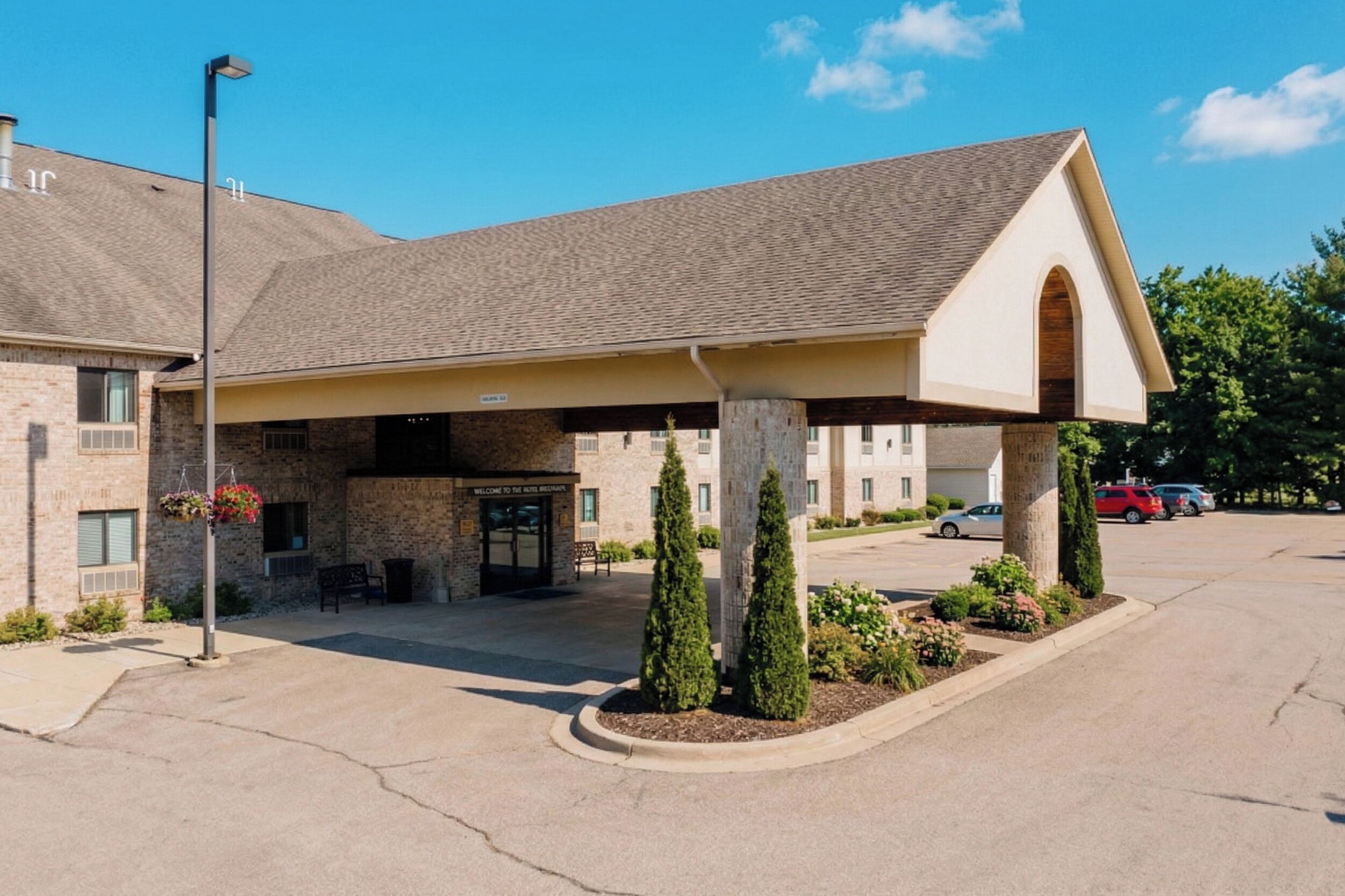 Un hôtel doté d’une entrée couverte, d’une façade en pierre et d’un parking.