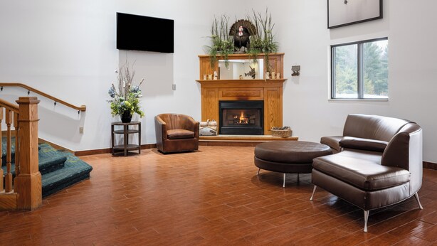 Una sala de estar con chimenea, muebles de cuero y una escalera.