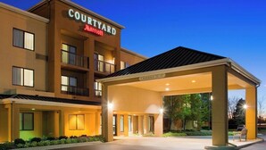 Un hotel Courtyard Marriott con una entrada cubierta y un cartel que indica el nombre.