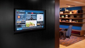Pantalla GoBoard en el vestíbulo de un hotel mostrando un mapa, noticias e información del mercado.