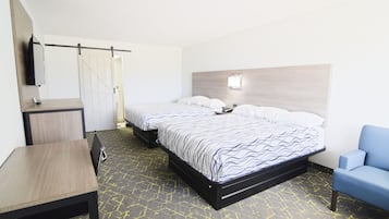 A hotel room with a bed, a desk, a chair, and a TV on the wall.