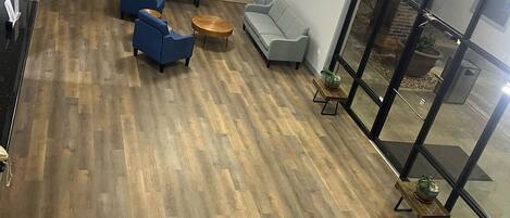 Una moderna area lounge con TV a schermo piatto, sedute confortevoli e pavimento in legno.