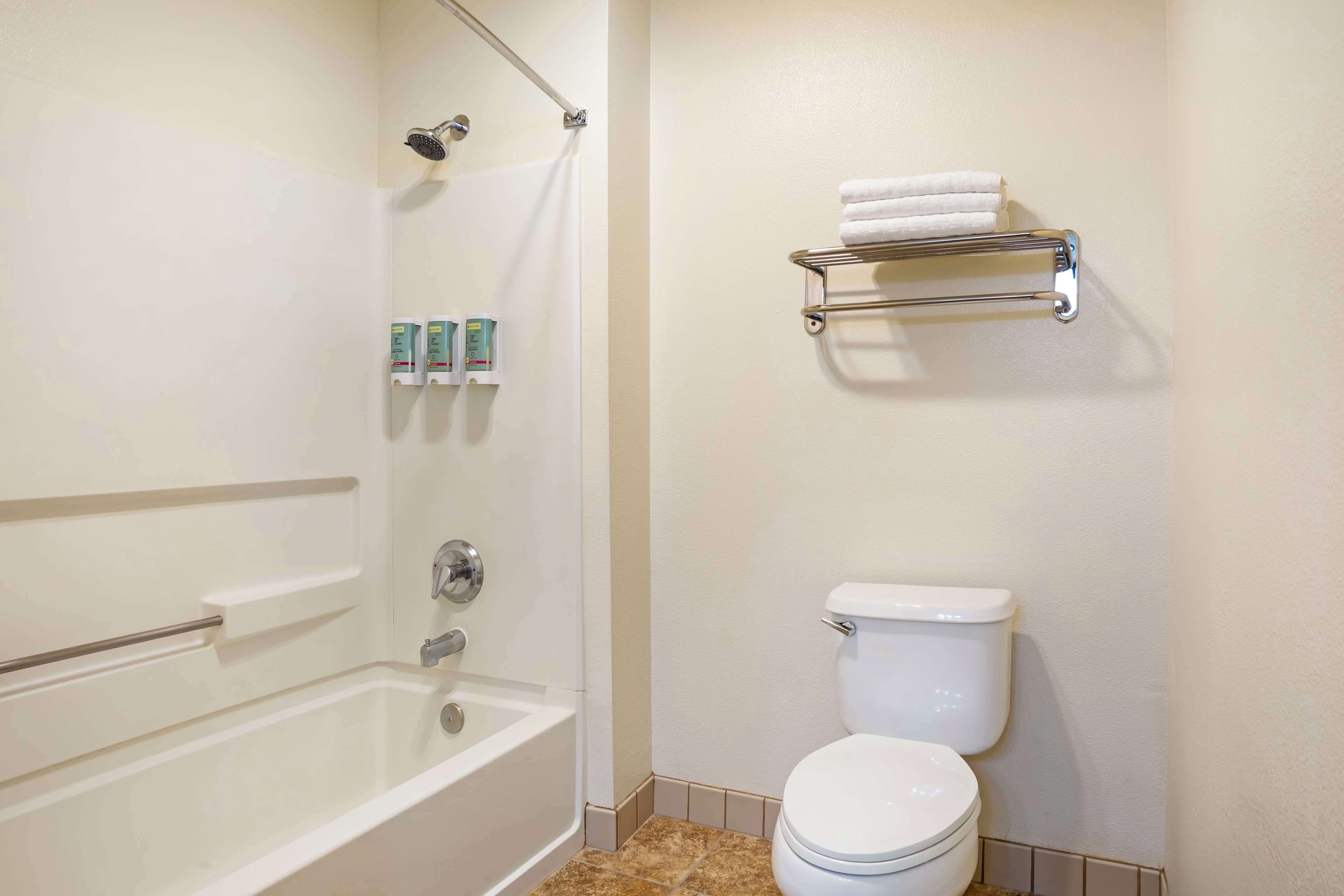 Ein Badezimmer mit Badewanne, Toilette und Handtuchhalter.