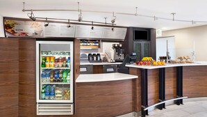 A modern bistro with a refrigerated beverage display, a coffee station, and a variety of food items on the counter. - Courtyard by Marriott Scottsdale North (Phoenix)