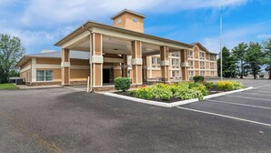 A hotel with a covered entrance, a central tower, and a parking lot. - Quality Inn Dry Ridge (Dry Ridge)