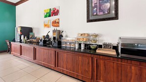 A breakfast bar with coffee machines, a waffle maker, and a display of pastries. - Quality Inn Dry Ridge (Dry Ridge)