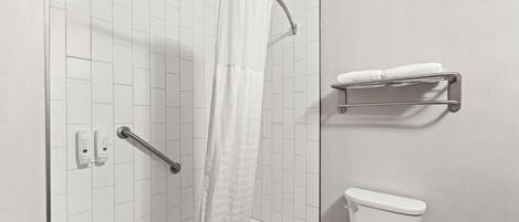 Un baño con ducha, inodoro y toallero.
