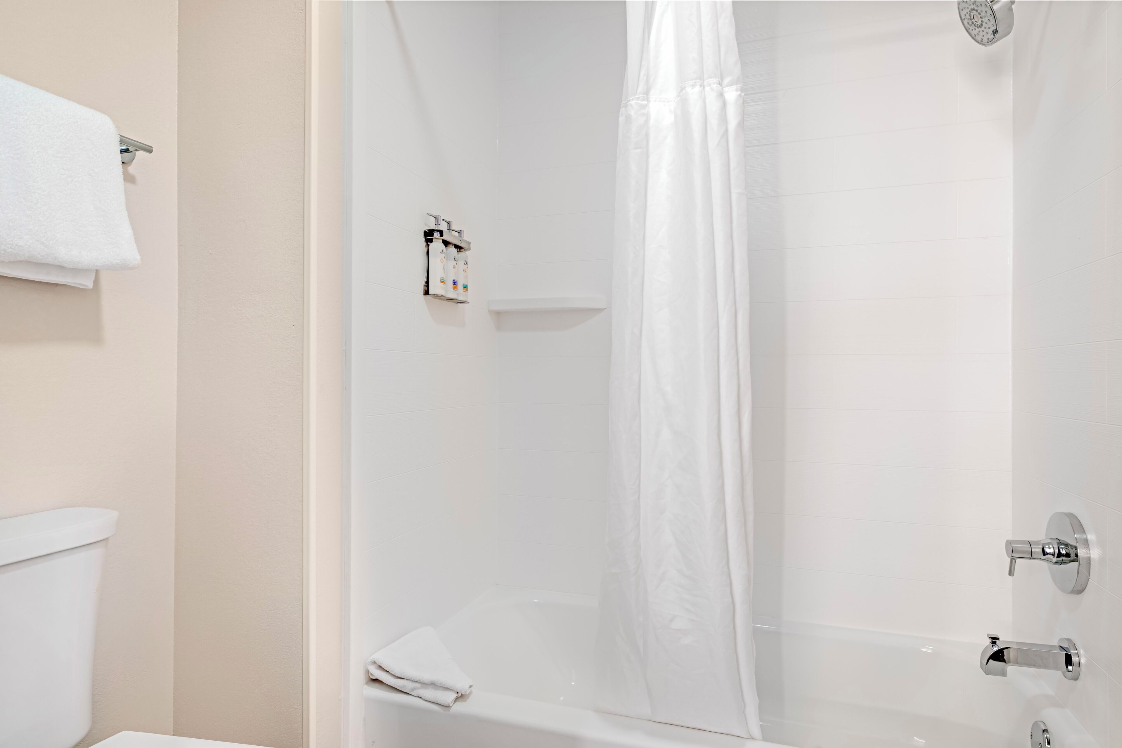 Un baño con bañera, cortina de ducha y retrete.