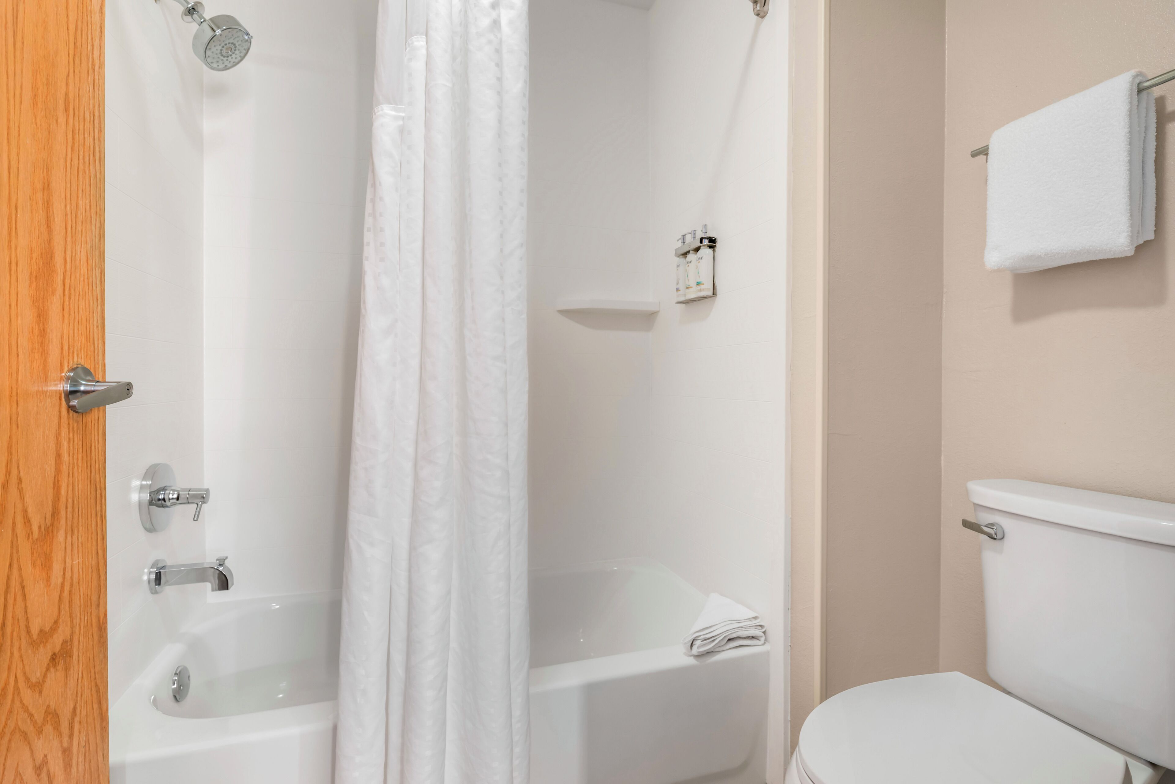 A bathroom with a bathtub, a sink, a toilet, and a shower curtain.
